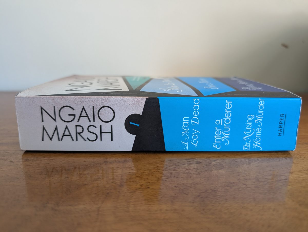 A photograph of the spine of the 2009 paperback edition of Harper's Ngaio Marsh omnibus, containing 'A Man Lay Dying', 'Enter a Murderer' and 'The Nursing Home Murder'. It is in very good condition.